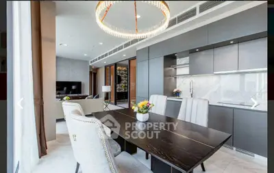 Luxurious open-plan kitchen and dining area with modern decor and elegant lighting.