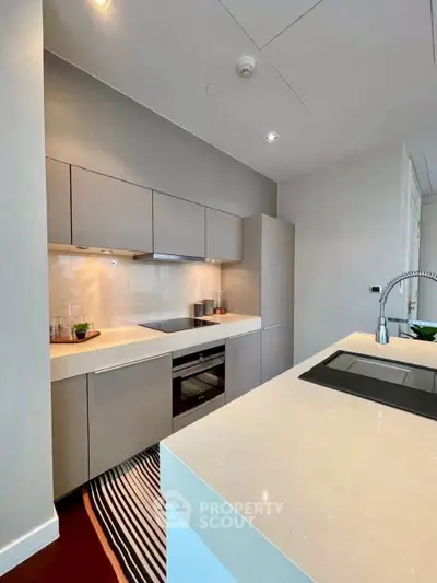 Modern kitchen with sleek cabinetry and integrated appliances in a stylish apartment.