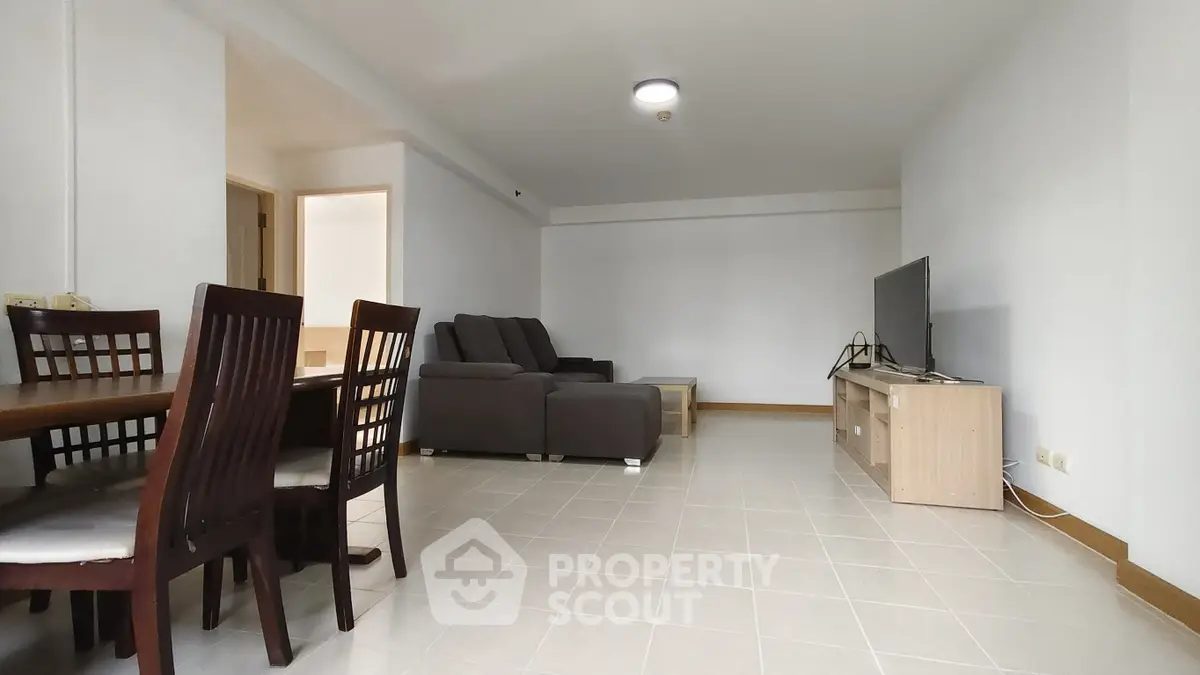 Spacious living room with modern furniture and dining area in a bright apartment.