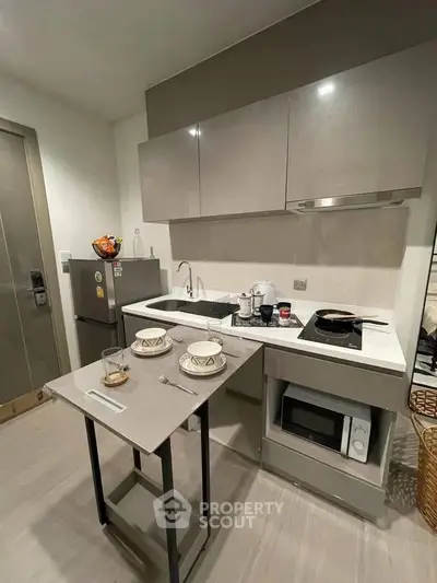 Modern compact kitchen with sleek cabinetry and integrated appliances in a stylish apartment.