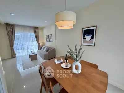 Modern living room with elegant dining area and cozy seating, featuring stylish decor and natural light.