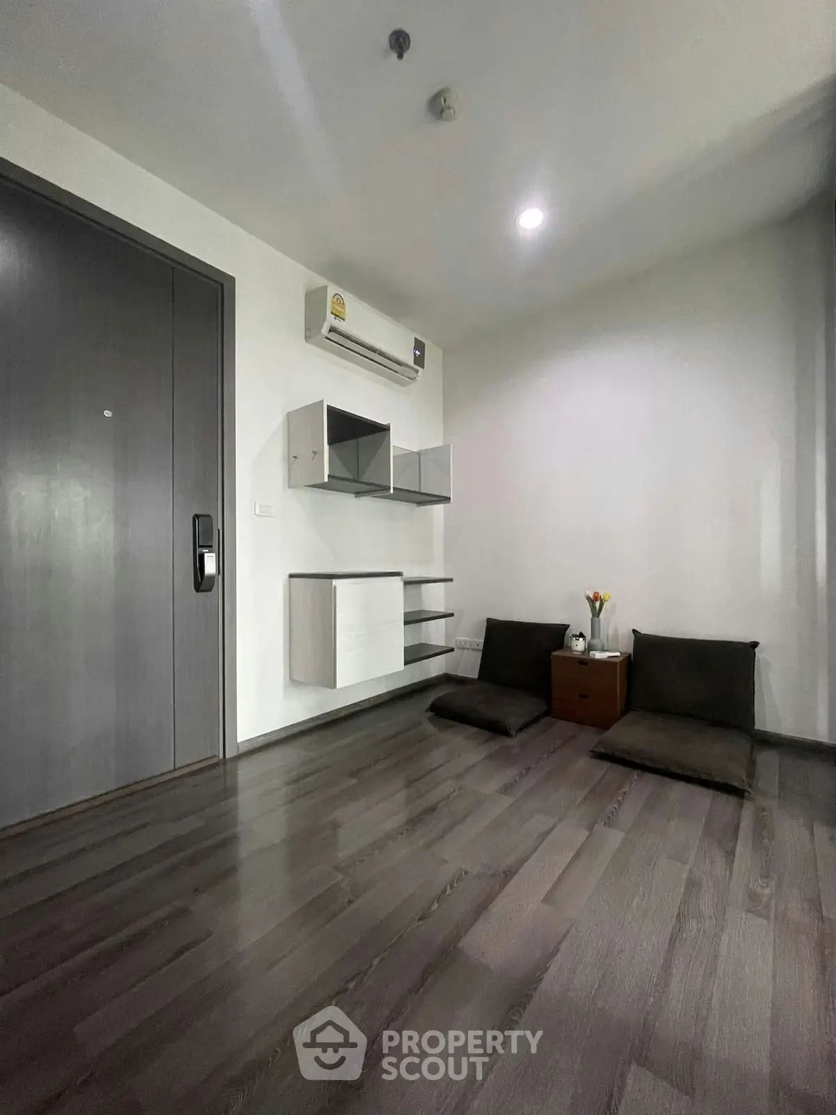 Minimalist living room with modern wall shelves and air conditioning unit