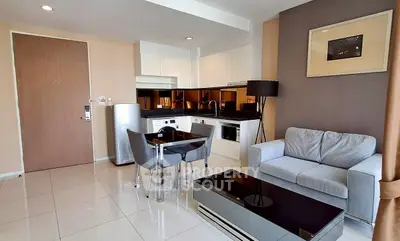 Modern open-layout living room with sleek kitchen, cozy sofa, and dining area in a stylish apartment.