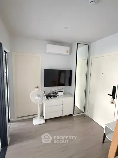 Modern living room with sleek design and neutral tones, featuring stylish decor and ample natural light.