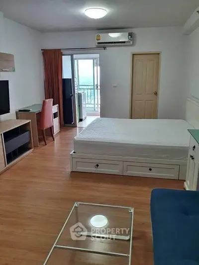Spacious studio apartment with modern furnishings and balcony view