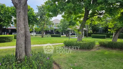 Beautiful garden view with lush greenery and residential houses in the background.