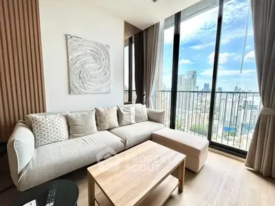 Modern living room with large windows offering stunning city views and cozy seating area.