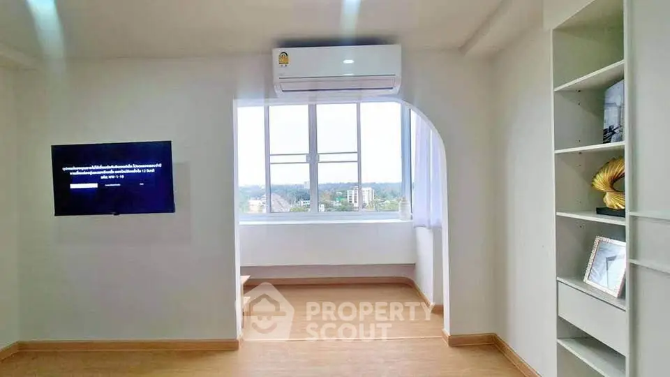 Bright living room with large window and modern decor in a stylish apartment.