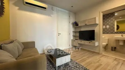 Modern living room with cozy sofa, wall-mounted TV, and air conditioning.