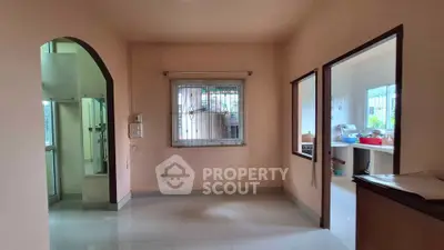 Spacious interior with open layout and natural light, featuring a kitchen and living area.