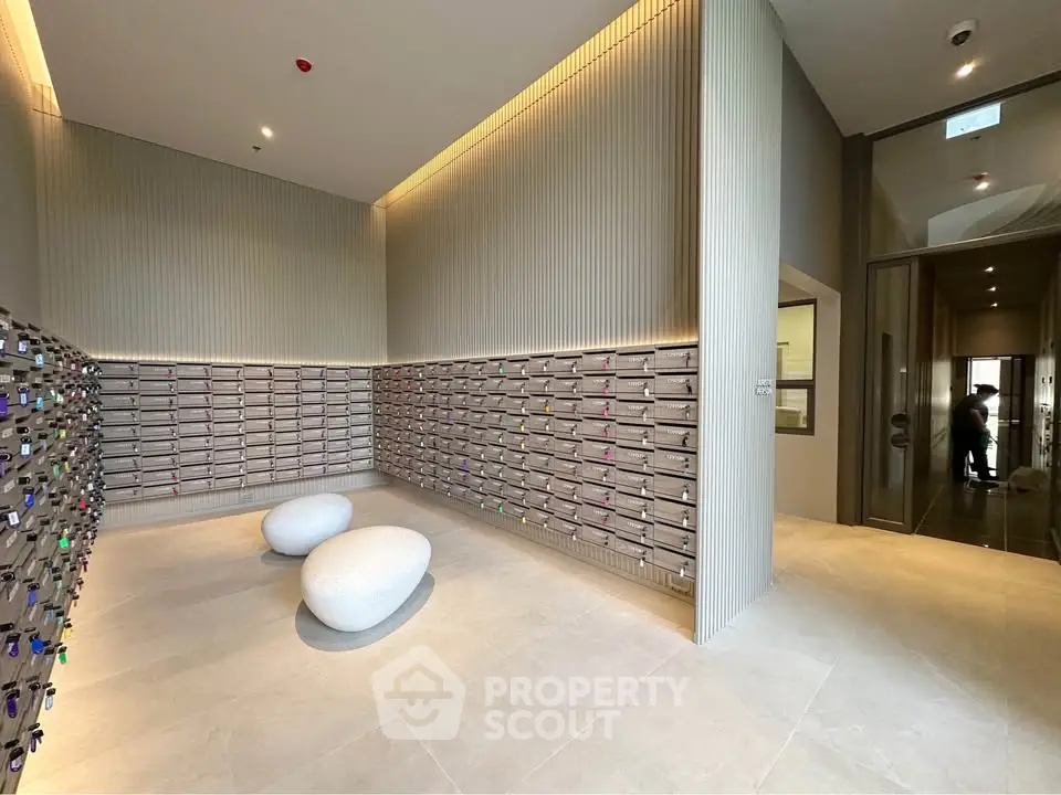 Modern apartment building entrance with stylish mailboxes and seating area.