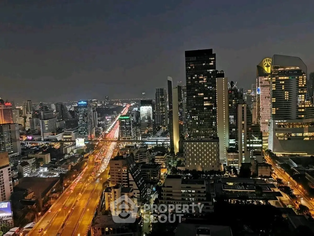 Stunning cityscape view from high-rise building at night with vibrant lights.