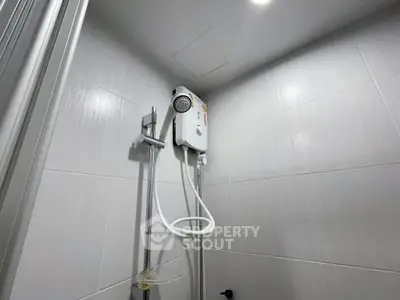 Modern bathroom shower with sleek water heater and minimalist design.