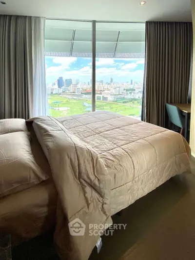 Luxurious bedroom with stunning city view from floor-to-ceiling windows, featuring elegant bedding and modern decor.
