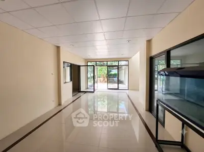Spacious interior with large windows and tiled flooring, ideal for versatile living or office space.