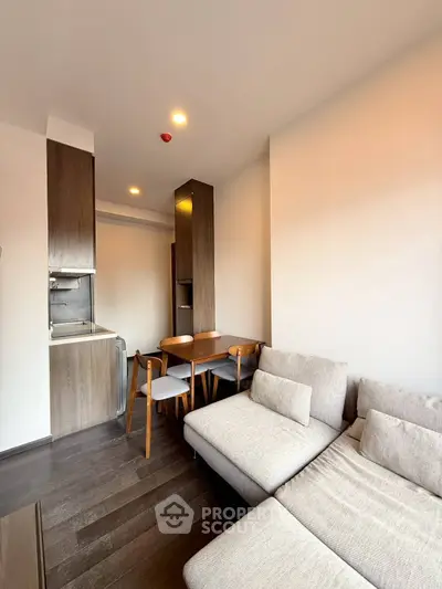 Modern living room with cozy sofa and dining area in open layout apartment.