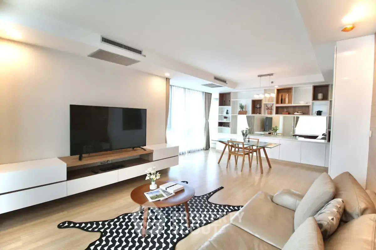 Spacious modern living room with elegant decor and large TV, perfect for relaxation.