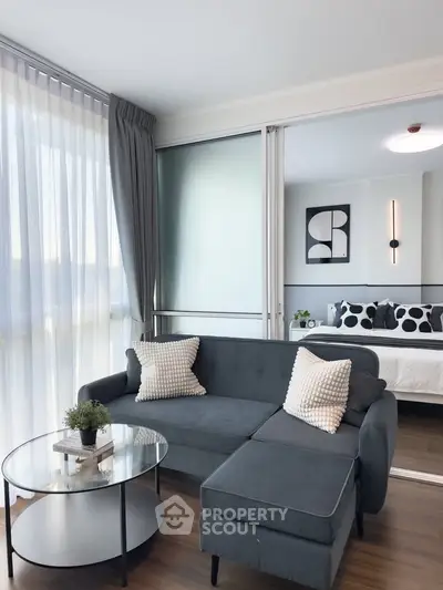 Modern living room with stylish decor and cozy seating adjacent to a chic bedroom.