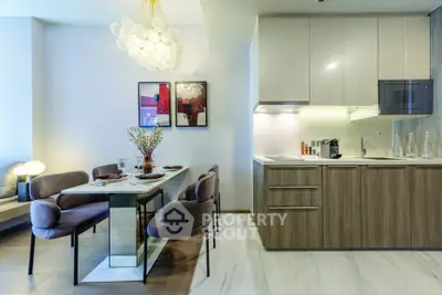Modern kitchen and dining area with sleek cabinetry and stylish lighting