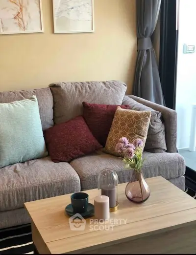 Cozy living room with stylish sofa and decorative pillows, perfect for relaxation.