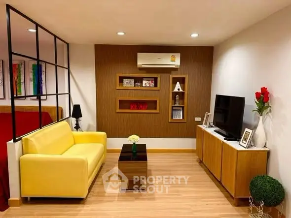 Stylish living room with yellow sofa, modern decor, and wall-mounted TV in a cozy apartment.