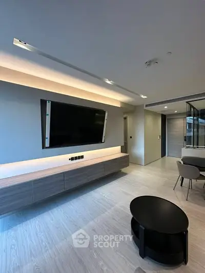 Modern living room with sleek design, featuring a large wall-mounted TV and stylish furniture.