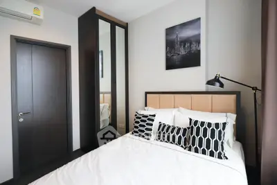 Modern bedroom with stylish decor and mirrored wardrobe in a contemporary apartment.
