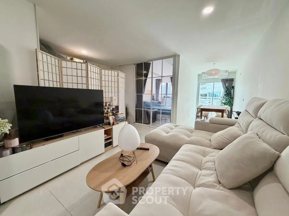 Spacious modern living room with cozy seating and large TV, perfect for relaxation.