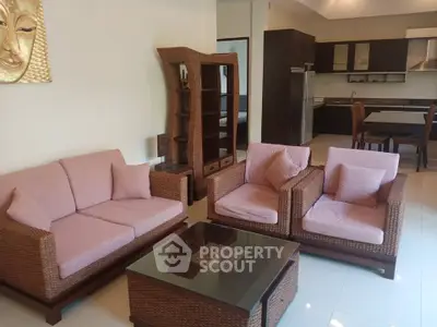 Stylish living room with wicker furniture and modern kitchen in open layout