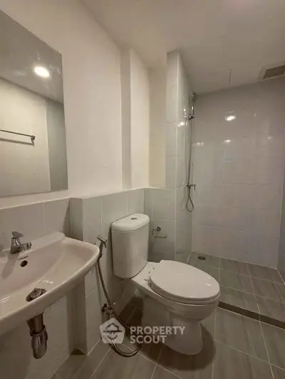 Modern bathroom with sleek fixtures and walk-in shower in a contemporary apartment.