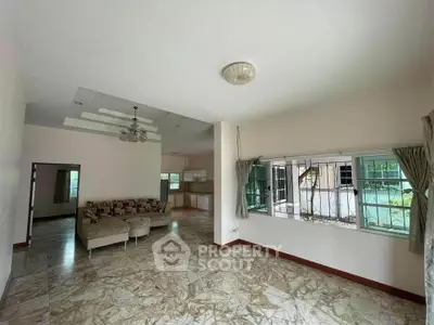 Spacious living room with marble flooring and large windows in a modern home