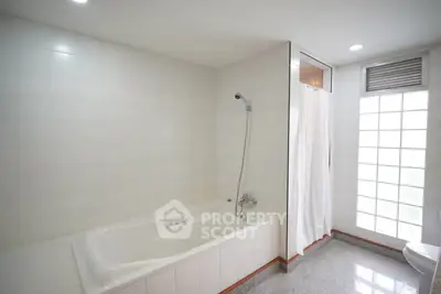 Spacious bathroom with bathtub and modern shower area