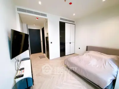 Modern bedroom with sleek design, featuring a wall-mounted TV and stylish flooring.
