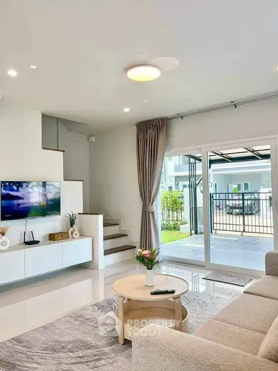 Modern living room with sleek design and garden view, featuring a cozy sofa and stylish decor.