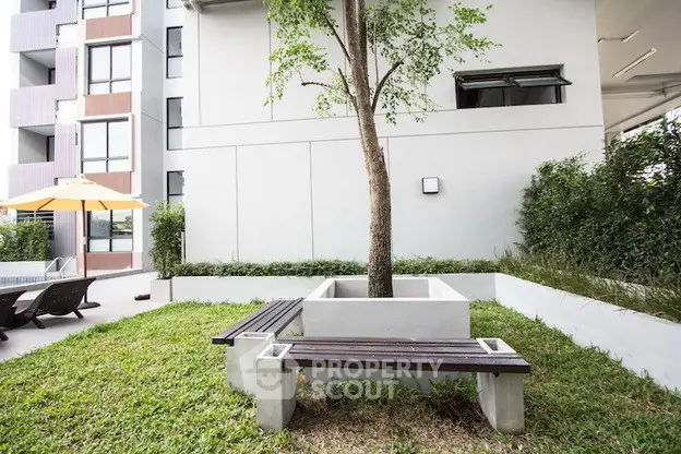 Modern apartment building with landscaped garden and seating area