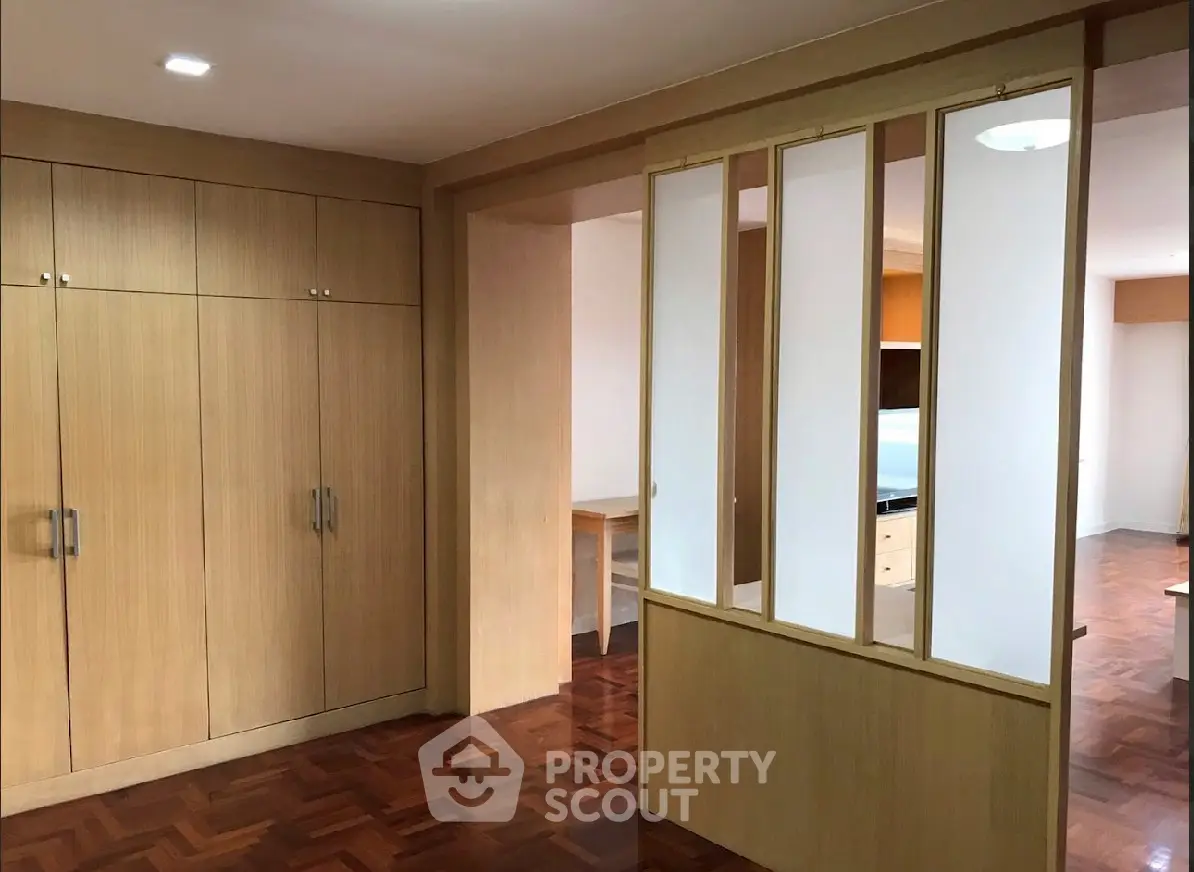 Spacious room with wooden flooring and built-in wardrobe