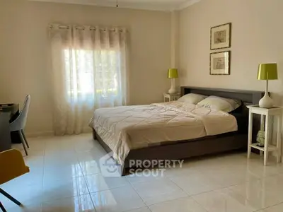 Spacious bedroom with modern decor and natural light