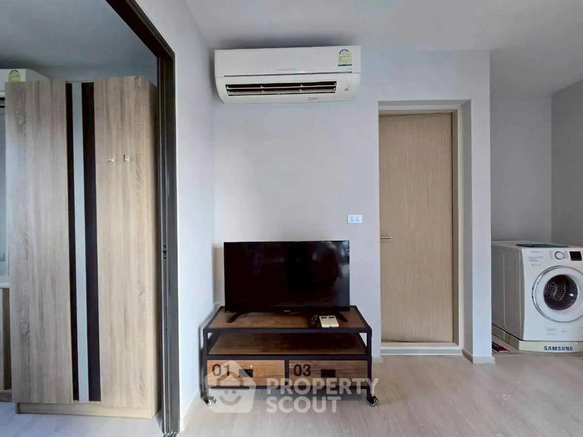 Modern apartment interior with air conditioning, TV, and washing machine.