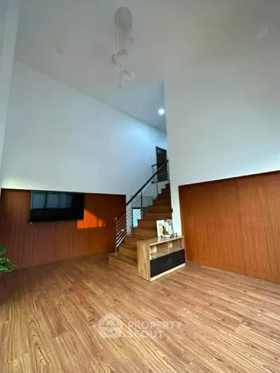 Spacious modern living room with wooden flooring and elegant staircase