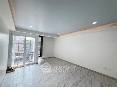 Spacious empty living room with modern flooring and large windows for natural light.