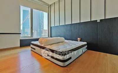 Modern bedroom with city view, featuring a minimalist design and large window for natural light.