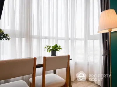 Bright corner unit with elegant curtains and cozy seating area