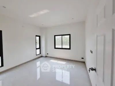 Spacious empty room with large windows and bright natural light, perfect for customization.