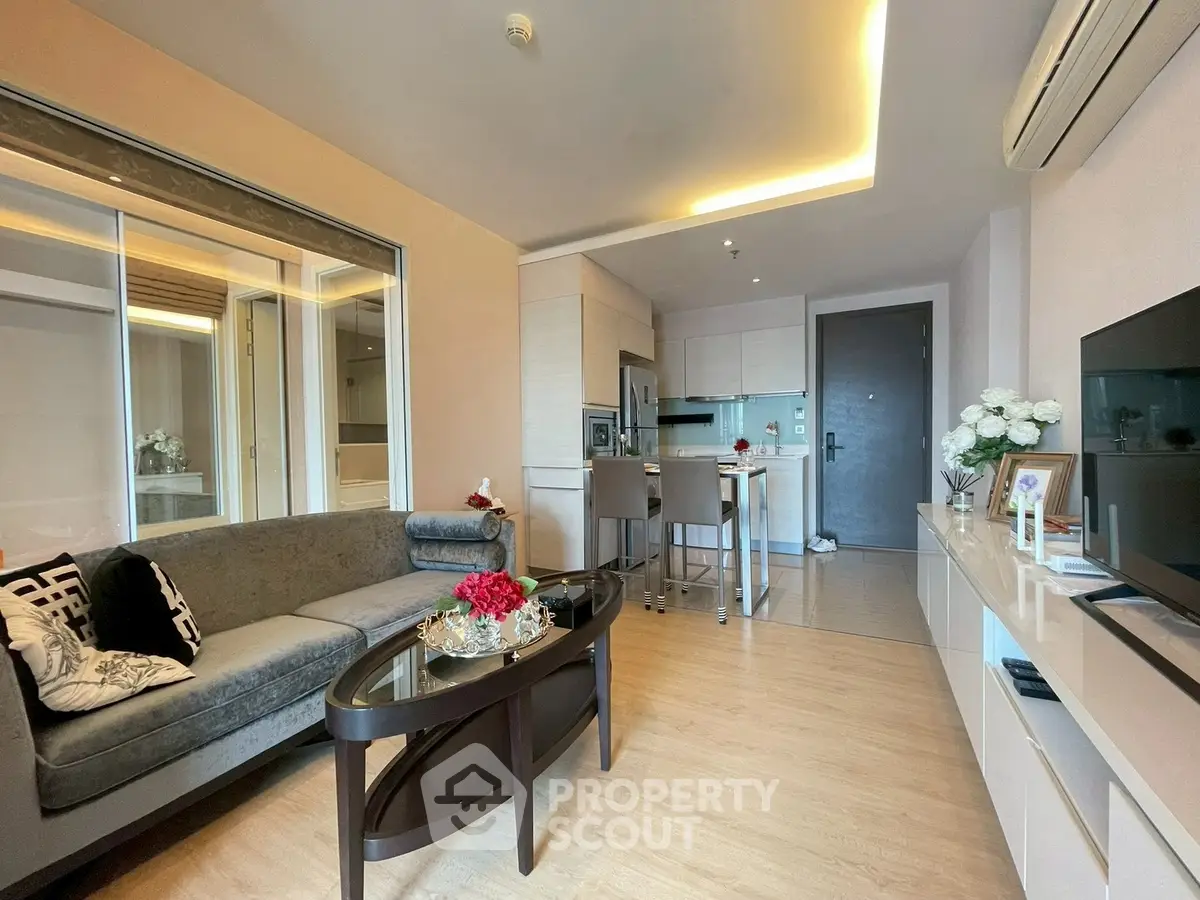 Modern living room with open kitchen, stylish decor, and cozy ambiance in a contemporary apartment.