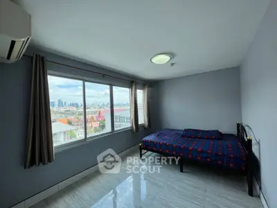 Spacious bedroom with city view and large windows in modern apartment