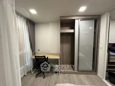 Modern bedroom with study area and sliding wardrobe in stylish apartment