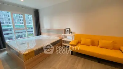 Modern bedroom with bright yellow sofa and large window view