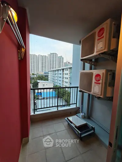 Urban balcony with air conditioning units and city view, ideal for compact outdoor space.