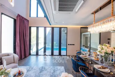 Luxurious living room with pool view, elegant dining setup, and modern decor in a spacious open layout.