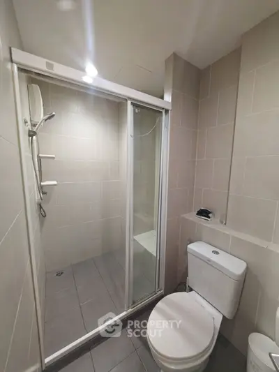 Modern bathroom with sleek shower and neutral tiles, perfect for a contemporary home.
